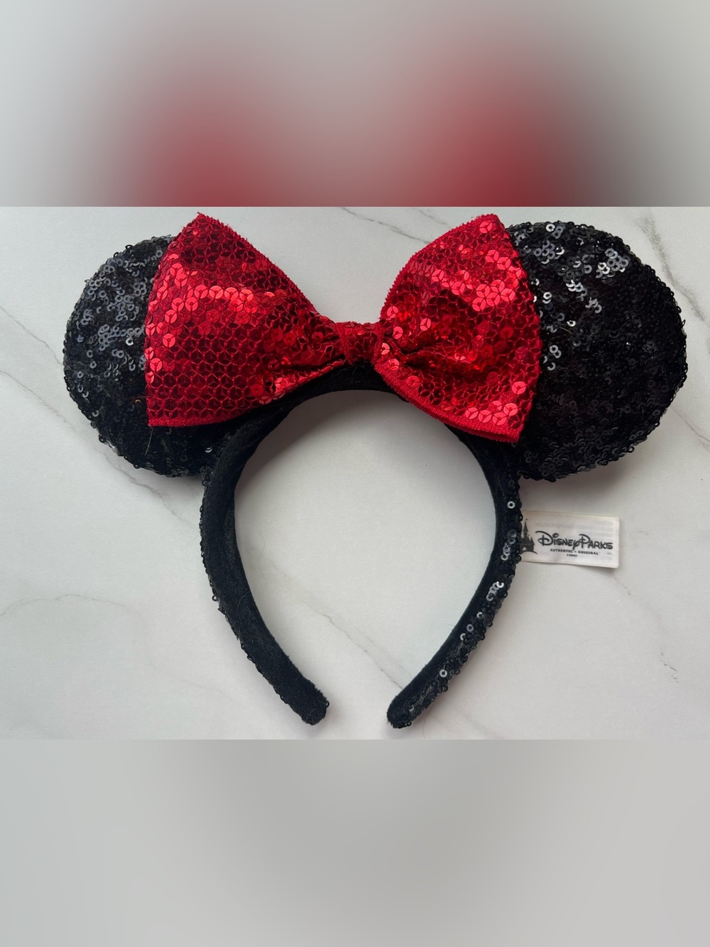 Disney Parks Authentic White Label, black sequin ears with a read sequin bow.
